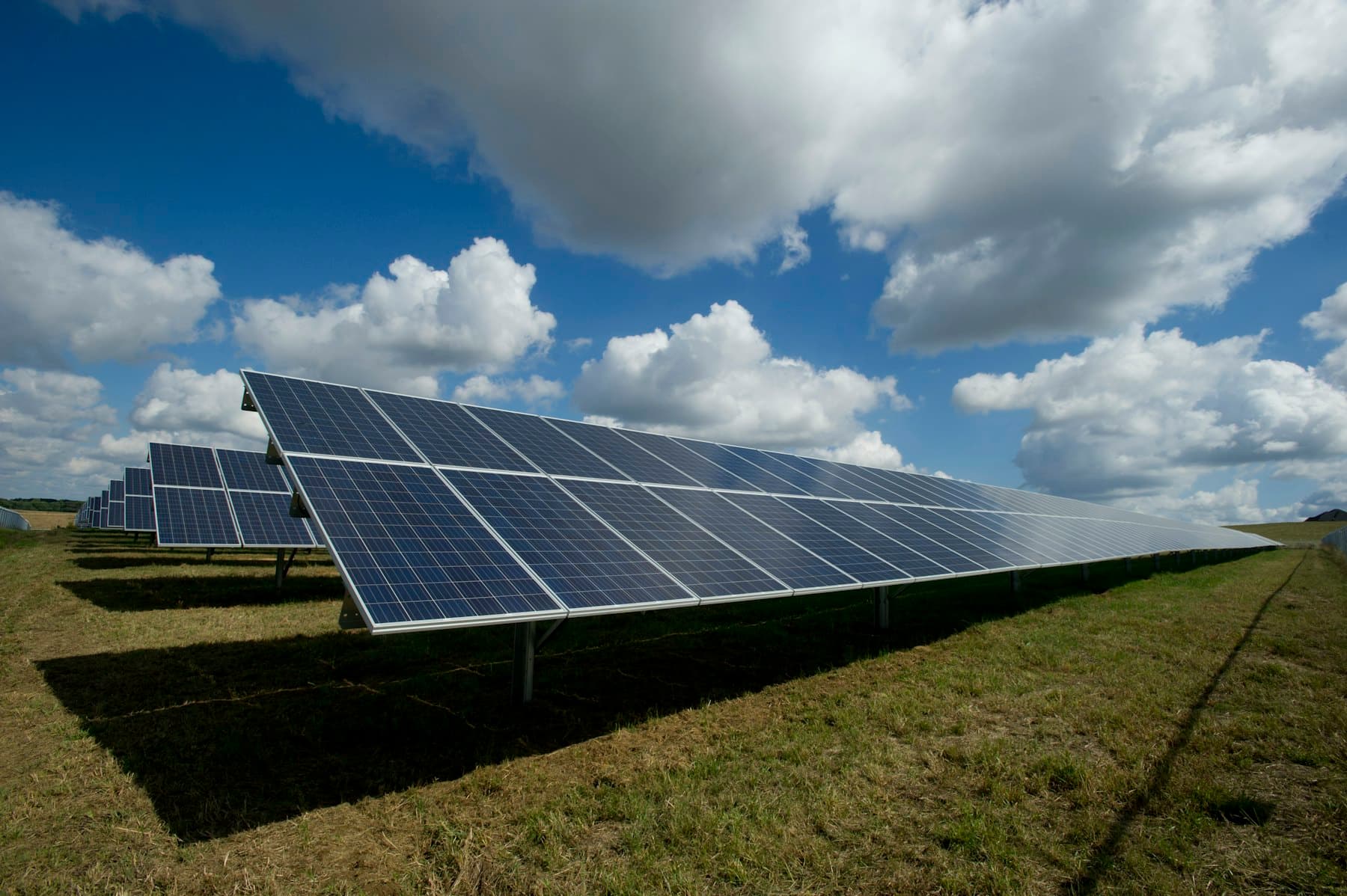 Ground-mounted solar panels under dramatic clouds