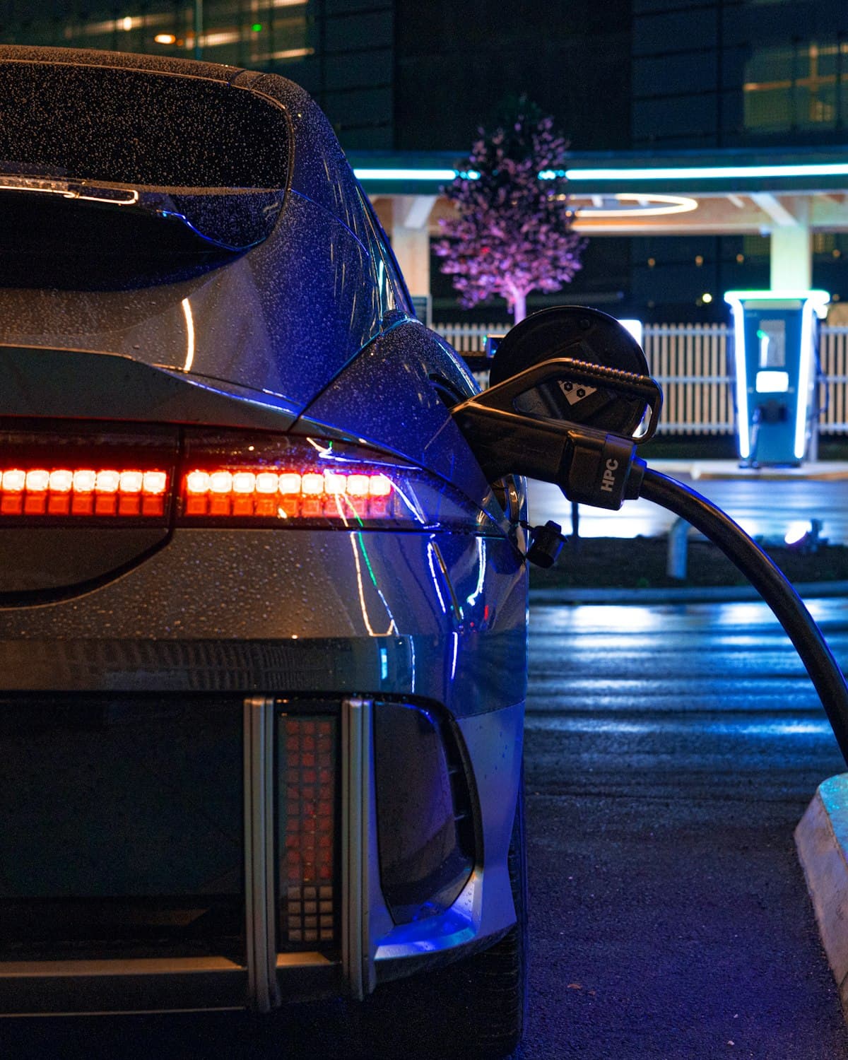 Electric car plugged into a high-power charger at night