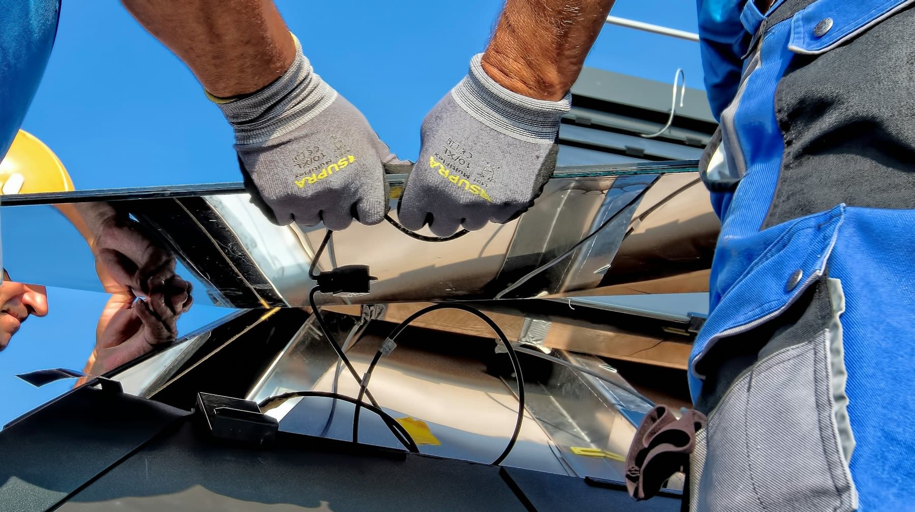 Technician's gloved hands connecting cables during an installation
